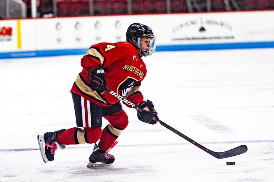 Junior defender Codie Cross moves the puck up the ice in a prior game against Vermont. Cross scored three points Friday on a goal and two assists.