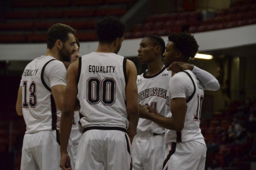 The Huskies huddle together on the court.