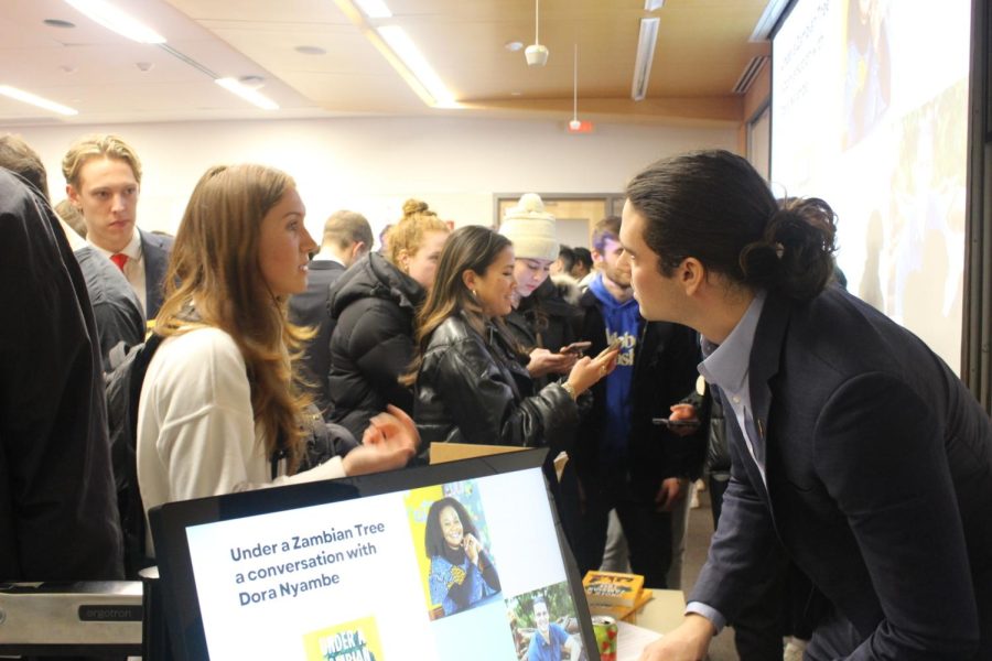 Joseph Schmitt, Northeastern alumnus and author of “Under a Zambian Tree,” signs copies of his book for students. The subject of Schmitt's book, Dora Moono Nyambe, spoke to students Feb. 28 about her experiences educating children in a remote village in Zambia. 