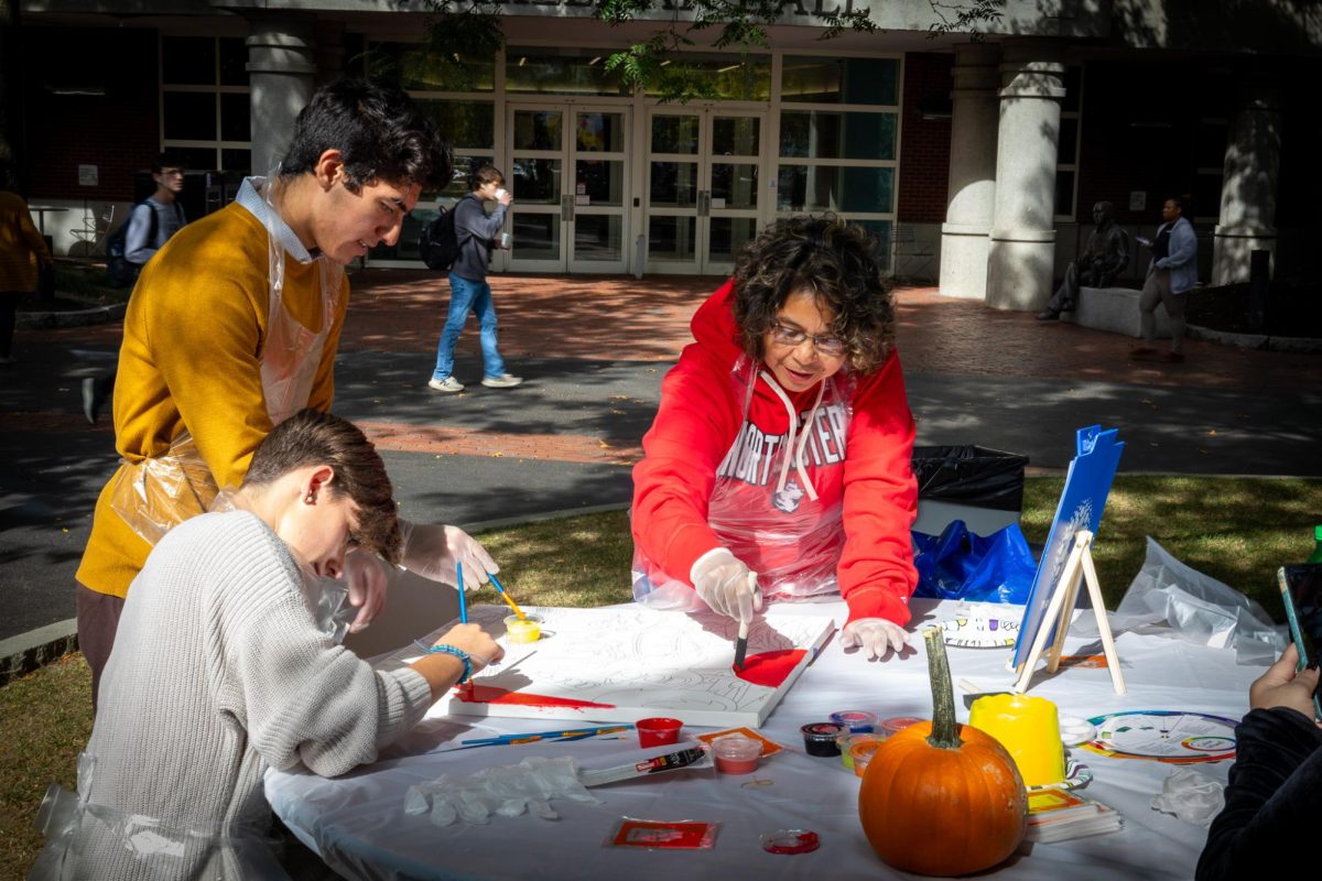 Festival attendees paint a canvas. Event staff provided reference photos and paint supplies to families taking part in the activity.