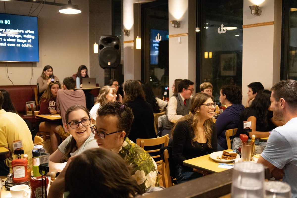 Participants at Friday Night Trivia discuss their answers to one of the round’s questions.  Teams were given one minute to confer with each other before moving onto the next question.