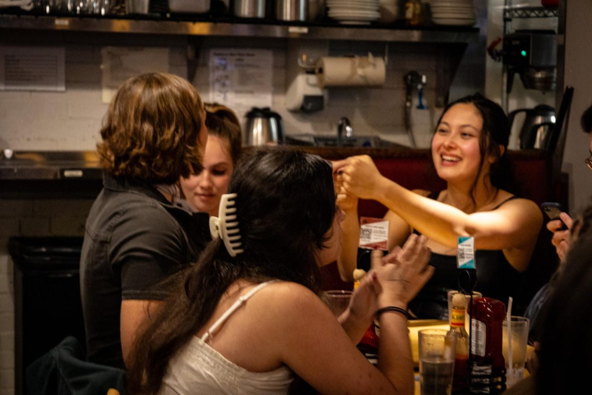 A team at Trident’s trivia night high-fives as they hear the host announcing the answers for the round. Upon finding out they had submitted the correct answers, they began to celebrate their success.