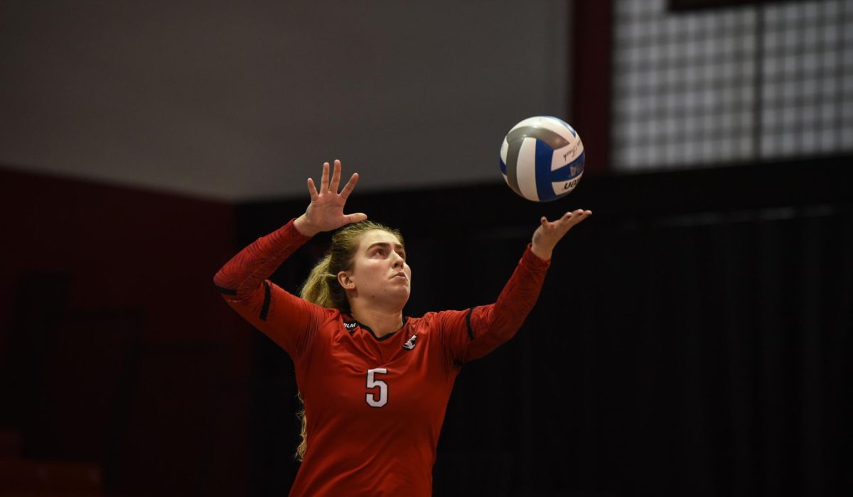 Graduate student outside hitter Julianna Truscott sets up to serve the ball. Truscott was one of six graduating Huskies celebrated in Sunday's senior day match.