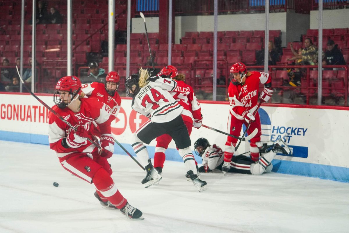 Jaden Bogden battles for possession of the puck against Boston University Oct. 11. The Husky notched the fourth and final goal over Holy Cross Oct. 19.