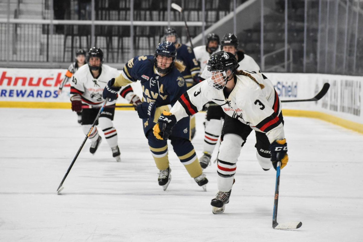 A skater rushes away from her opponent. The Women's Club Ice Hockey Team lost during the play pool round, ending their season March 21-25. Photo courtesy Mary Tran. 