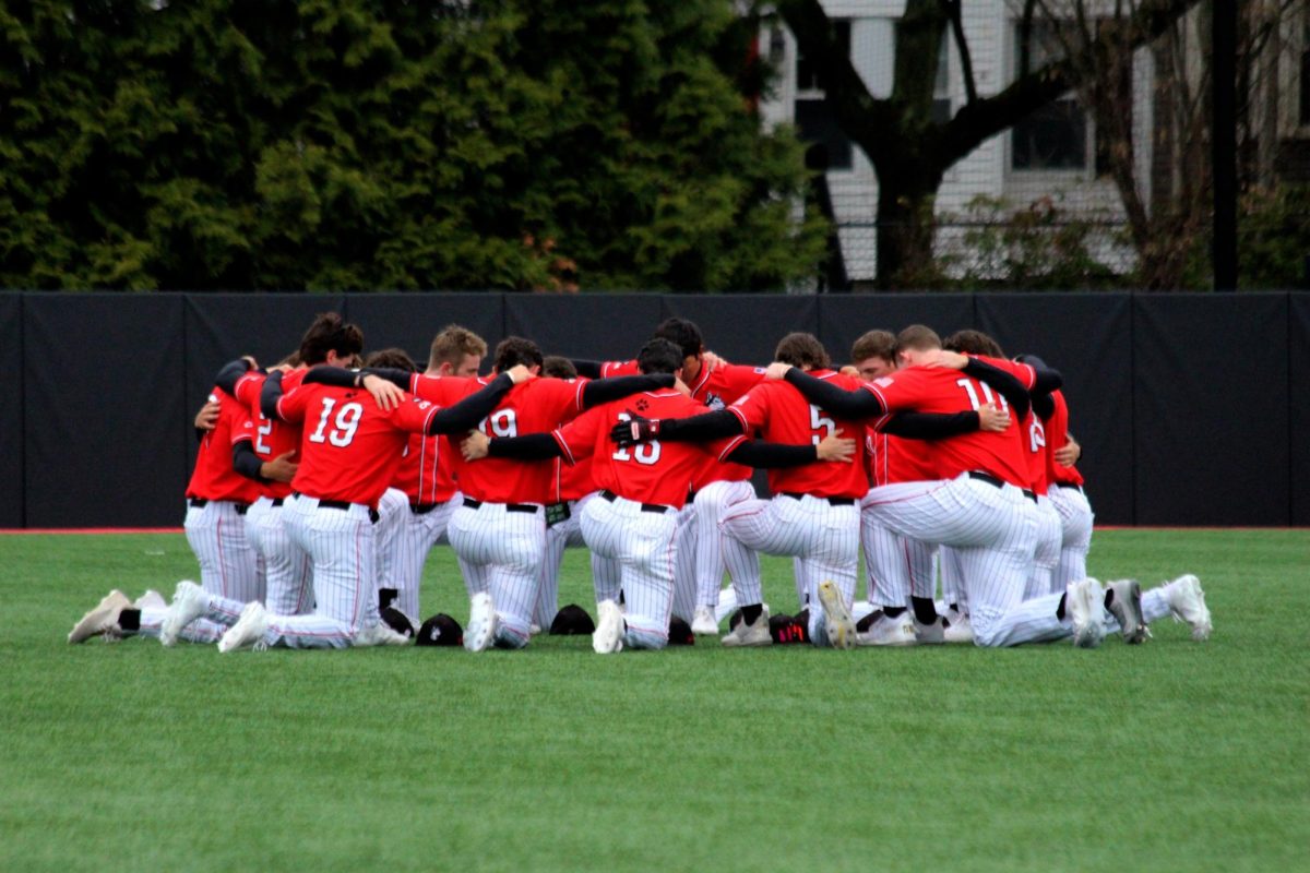 The team huddles before the game April 13. The Huskies swept the University of Delaware in a three game series.